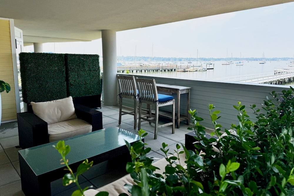 An outside terrace with a sofa, plants, and a view of Manhasset Bay